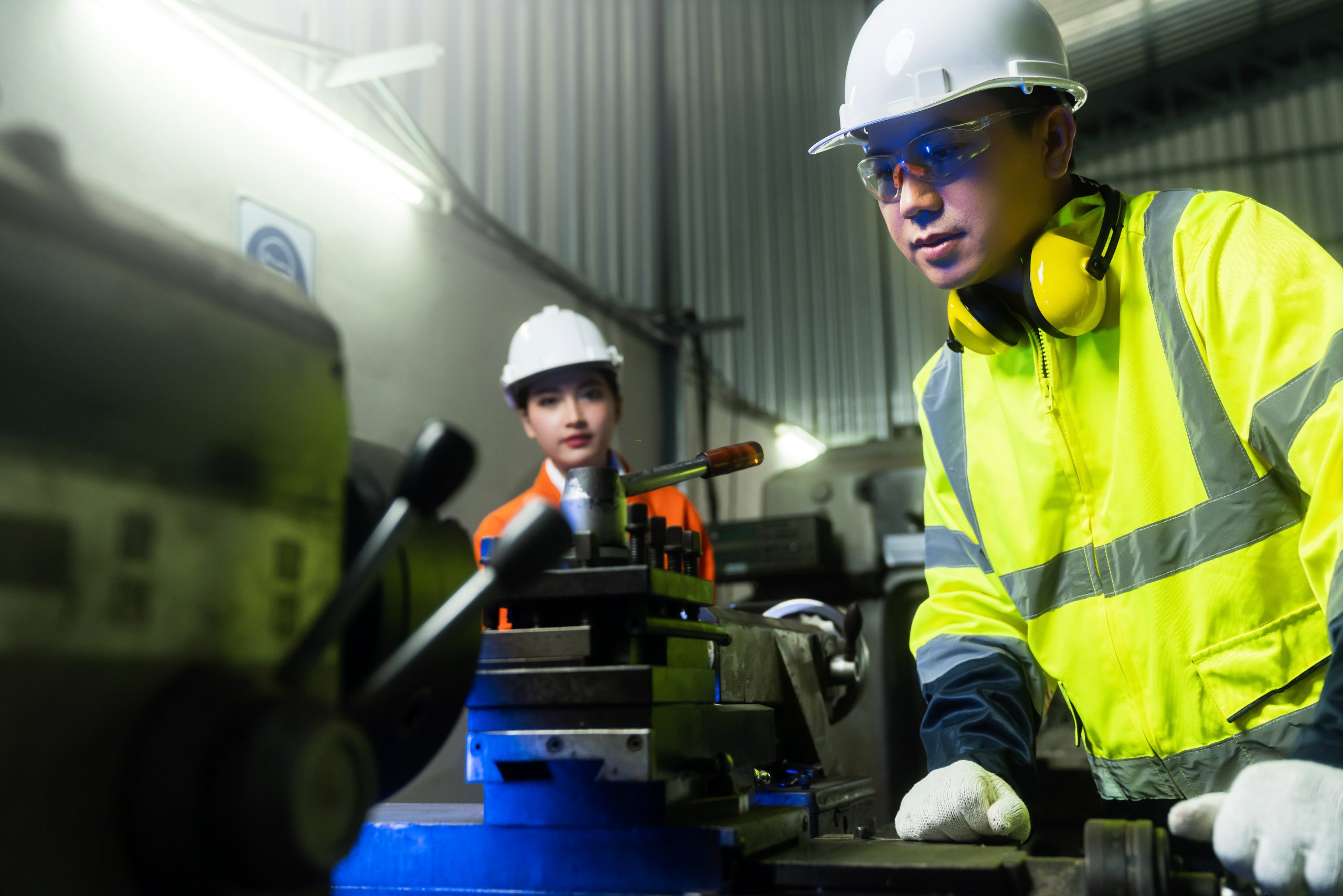 engineer cooperation Two asian maintenance engineers men and women inspect relay protection system with tablet device to control quality control process work a heavy industry manufacturing factory