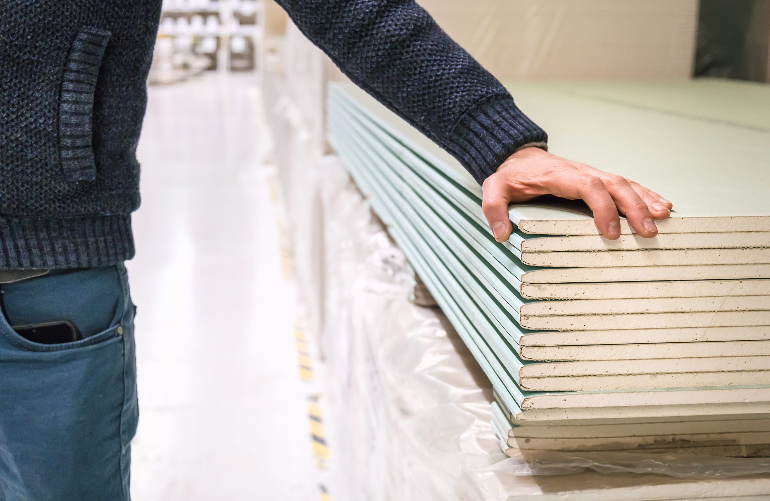Drywall is sold in the store. Selective focus. People.